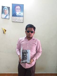 graphic மாபெரும் தமிழ்க்கனவு நூலைக் கையில்  ஏந்தியபடி ப. சரவணமணிகண்டன்